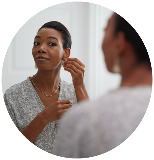 Black Woman Smiling As She Puts On Earrings